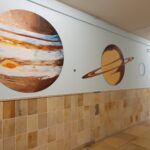 Unser Gebäude 67 Das Bild zeigt gemalte Planeten an der Wand im Schulflur