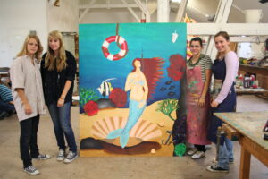 Das Bild zeigt Schülerinnen, die ihr gemaltes Bild präsentieren