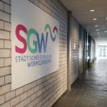 Unser Gebäude 19 Das Bild zeigt das Logo des Gymnasiums Wermelskirchen gemalt im Schulflur hängend