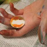 Unser Gebäude 69 Das Bild zeigt eine Hand mit einer bemalten Kugel