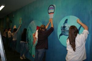 Das Bild zeigt Schülerinnen und Schüler bei der kreativen Schulgestaltung